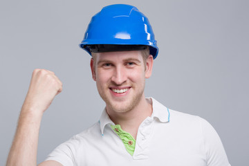 Junger Mann mit Helm freut sich und zeigt die Siegesfaust