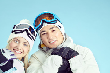 Happy couple of snowboarders  smiling at camera