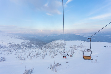Fototapeta na wymiar Winter mountains panorama with ski slopes and ski lifts