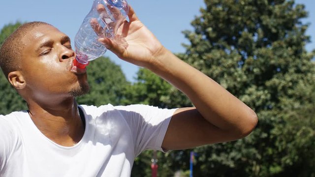 Athlete taking a water break on a hot day, in slow motion