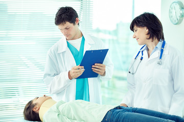 Two doctors examining patient in hospital