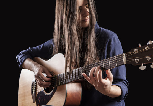 beautiful young woman playing acoustic guitar