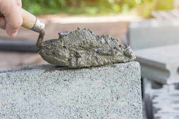 Cement or mortar, Cement mix with a trowel in a hand on the brick for construction work.