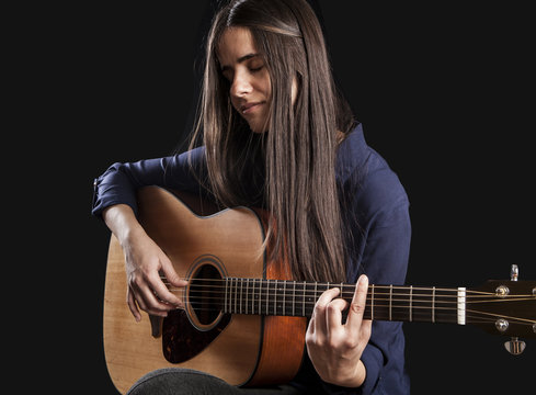 beautiful young woman playing acoustic guitar