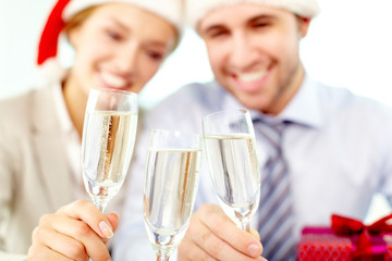 Two business people clinking glasses, the focus is on champagne flutes