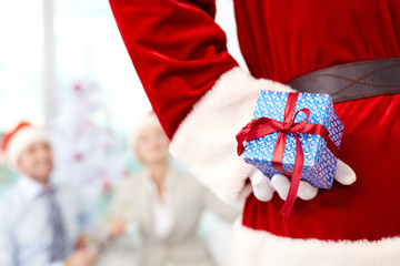 Rear view of Santa Claus holding gift box behind his back