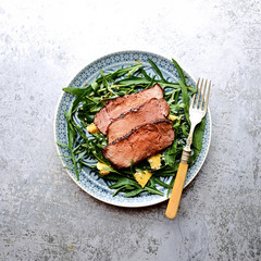 salad of arugula and roast beef on a gray background