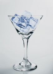 Ice cubes and glass of alcohol martini studio shot