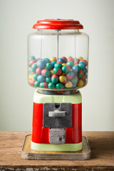 gamble eggs in vintage coin operated gumball machine on old wood