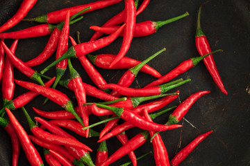Chili peppers on dark rusty background