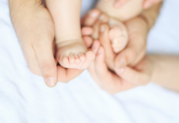 mom hugs baby's legs. Positive human emotions, feelings