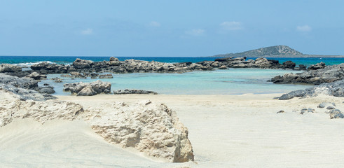 Fototapeta na wymiar Rocky wild beach with azure clear color water