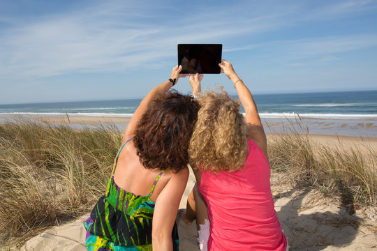 Happy women enjoying vacation taking selfie photo