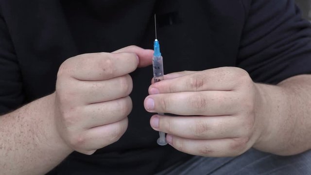 Drug addict man with syringe