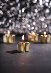 Brennende goldene Kerzen vor glitzerndem Bokeh Hintergrund, Weih