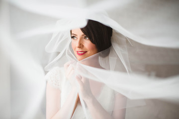 gorgeous bride was covered with a white veil