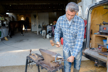 Farrier shaping horseshoe