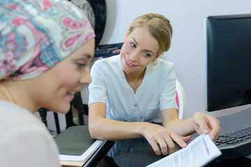 Lady wearing headscarf reading leaflet