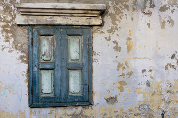 Old wood window in blue color on old wall.