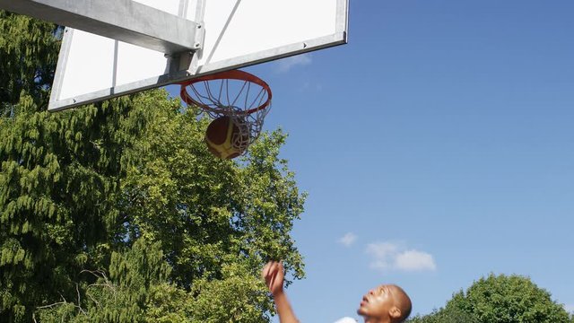 Basketball player doing a fancy 360 degree slam dunk, in slow motion