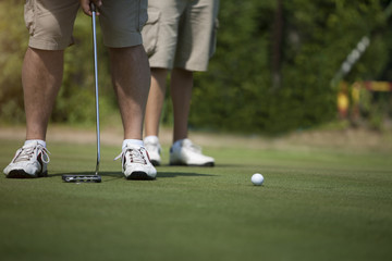Men golfing on green