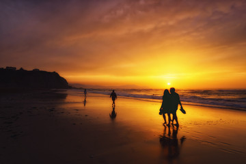 Fototapeta na wymiar people walking on beach at sunset