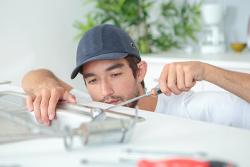 young plumber fitting a sink