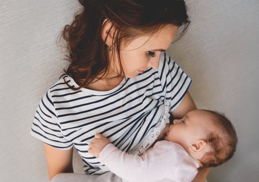 Beautiful Young Mom Breastfeeding Her 5 Months Baby. Mather Nursing Baby. Family At Home.