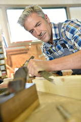 Carpenter working wood in workshop