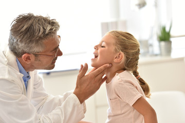 Doctor examining little girl's throat © goodluz