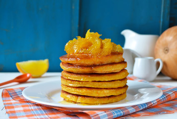 Pancake with pumpkin and orange on a blue background