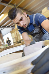 Young man in woodwork crafstmanship school, training course