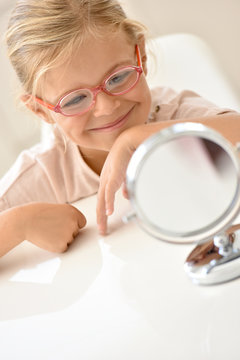 Little girl at the optician trying different eyeglasses