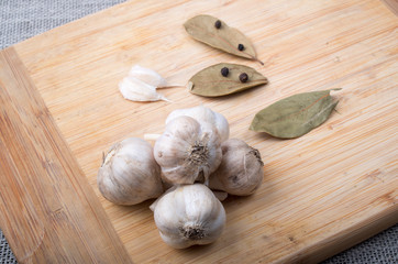 Wooden board with garlic, dried bay leaves and sweet peas