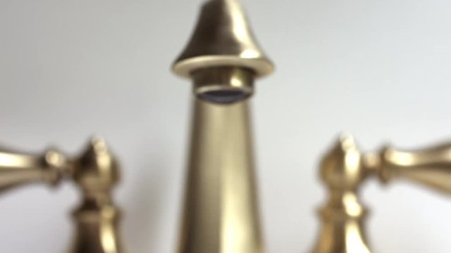 Dramatic Footage of Leaking Bathroom Getting in Focus Faucet Over Gray Background.