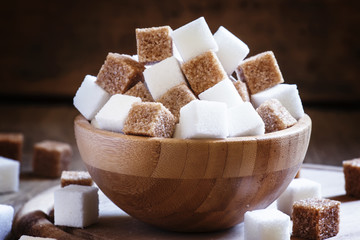 Refined sugar cubes, vintage wooden background, selective focus