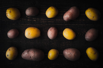 Pattern of raw potatoes on the old wooden background