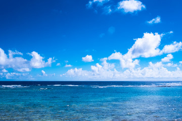 Naklejka na ściany i meble 日差しの中の沖縄の青い海と輝く雲