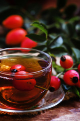 Healing black tea with wild rose berries in a glass cup. Vintage