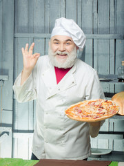 Bearded cook with pizza