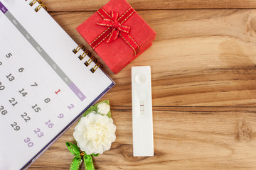 pregnancy and  calendar red gift boxes on a wooden table