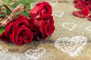 Red roses bouquet with ribbon on stone table