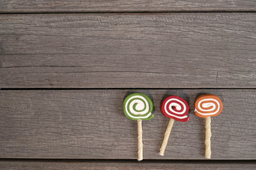 Lollipops dog treats isolated on wooden background (dog snack), copy space for text, top view (lollipop's sticks are made from bones)