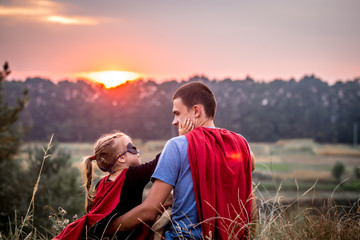 little girl with dad dressed in super heroes, happy loving family