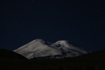 Snowy mountain Elbrus in moonlight and stars at night