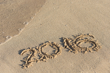 Inscription 2016 on sandy beach with wave's foam