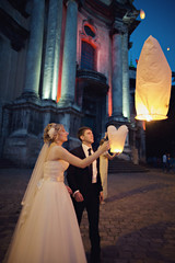 The bride and groom are looking how  Chinese lantern flying