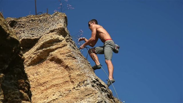 Extreme Climber Climbing A Rope From A Rock