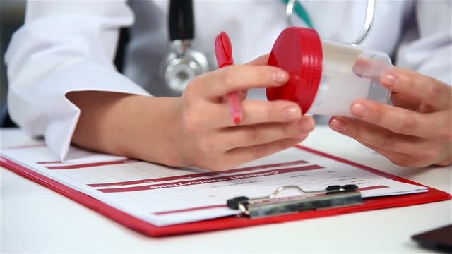 Doctor Writes A Prescription And Makes An Entry In A Personal Medical Card