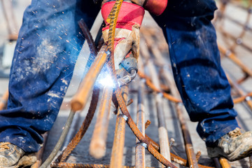 Obraz premium Close up of the hands welder worker with electrode